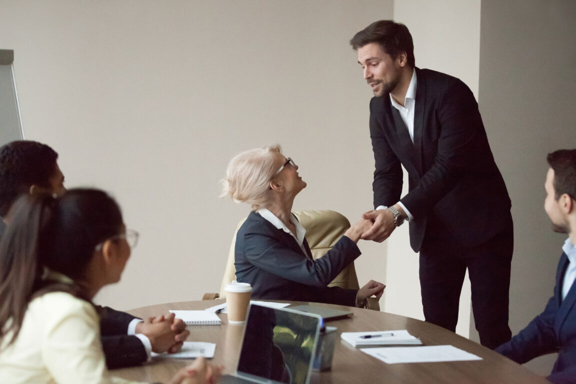 businessman and businesswoman shaking hands during meeting