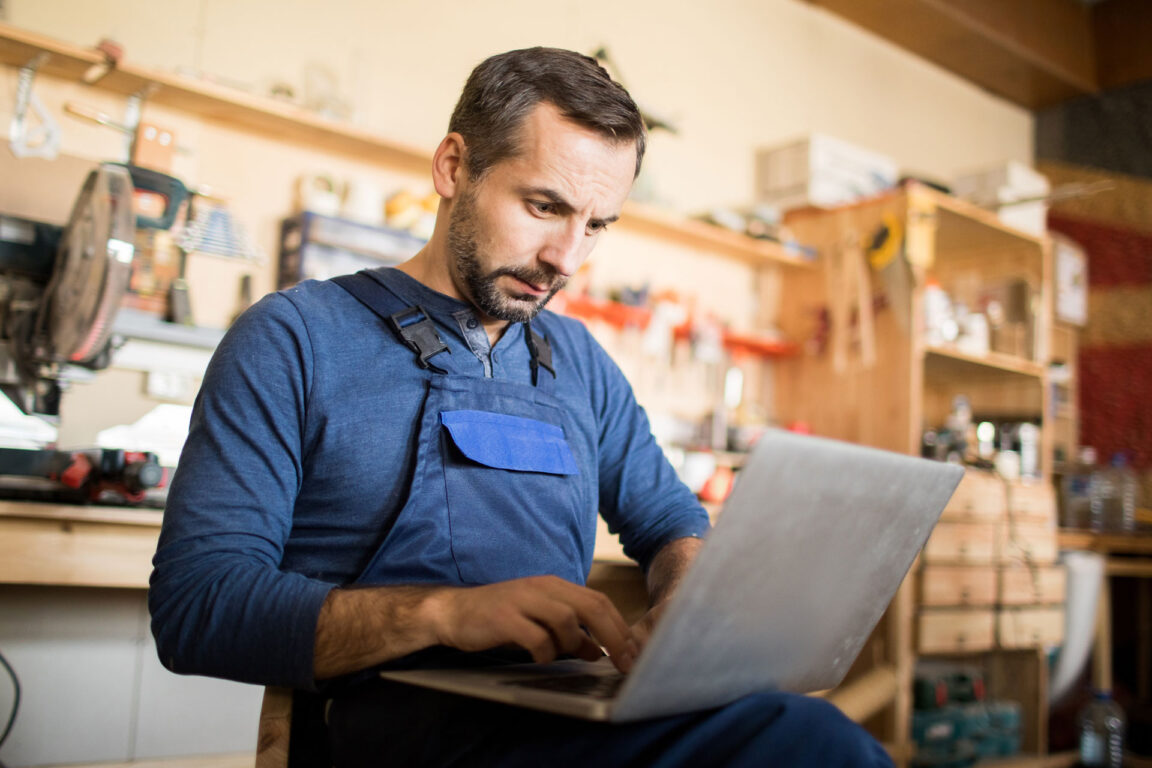 man sitting with laptop managing a small business