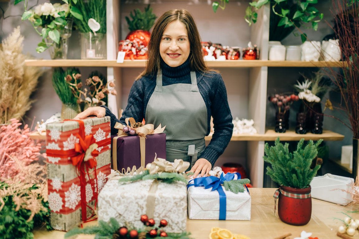 seller-with-gift-boxes-in-festive-wrapping-paper small business owner wrapping gifts